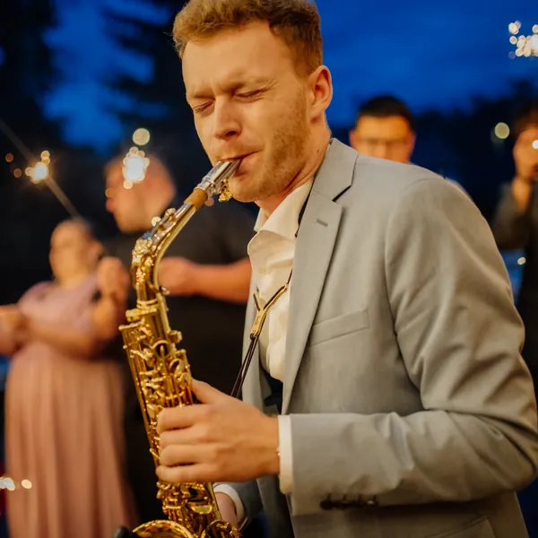 Saxofonista OSKARSAX hraje večer na svatbě mezi hosty s prskavkami