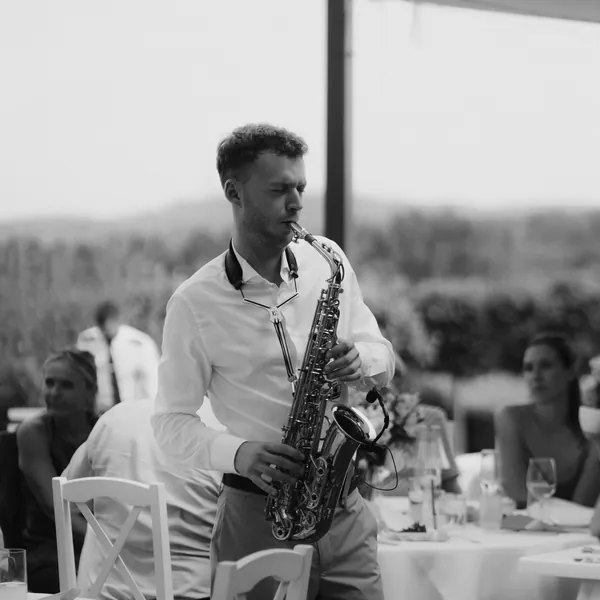 Saxofonista OSKARSAX hraje mezi stoly svatebních hostů